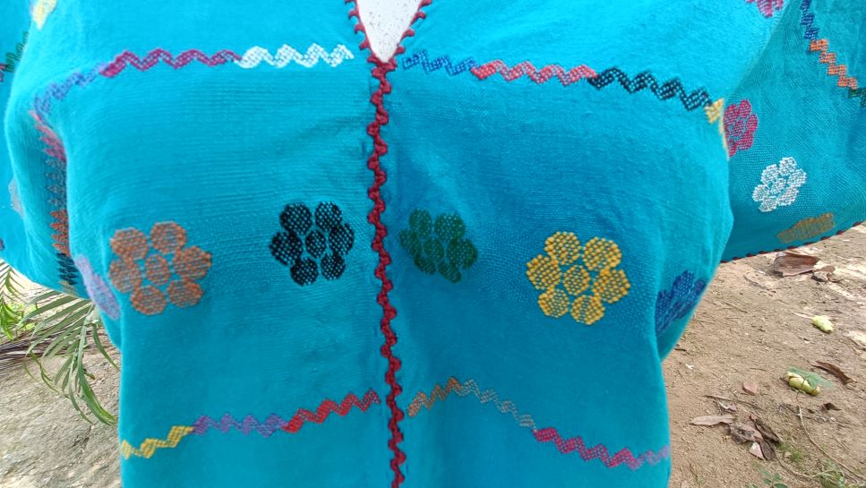 BLUSA DE TELAR DE CINTURA COLOR AZUL CON FLORES COLORIDAS.