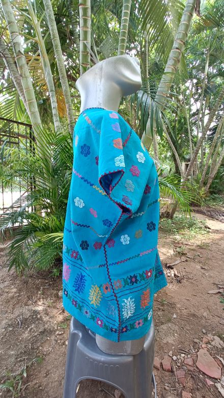 BLUSA DE TELAR DE CINTURA COLOR AZUL CON FLORES COLORIDAS.